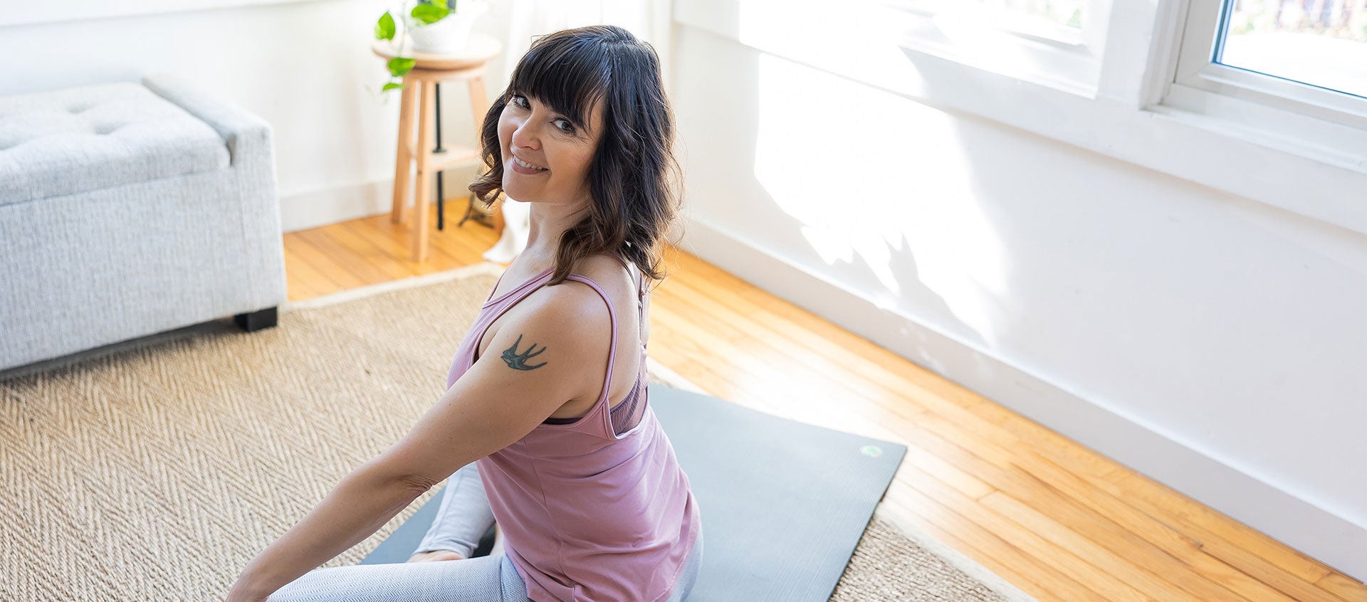 Jennifer Reis woman smiling on yoga mat