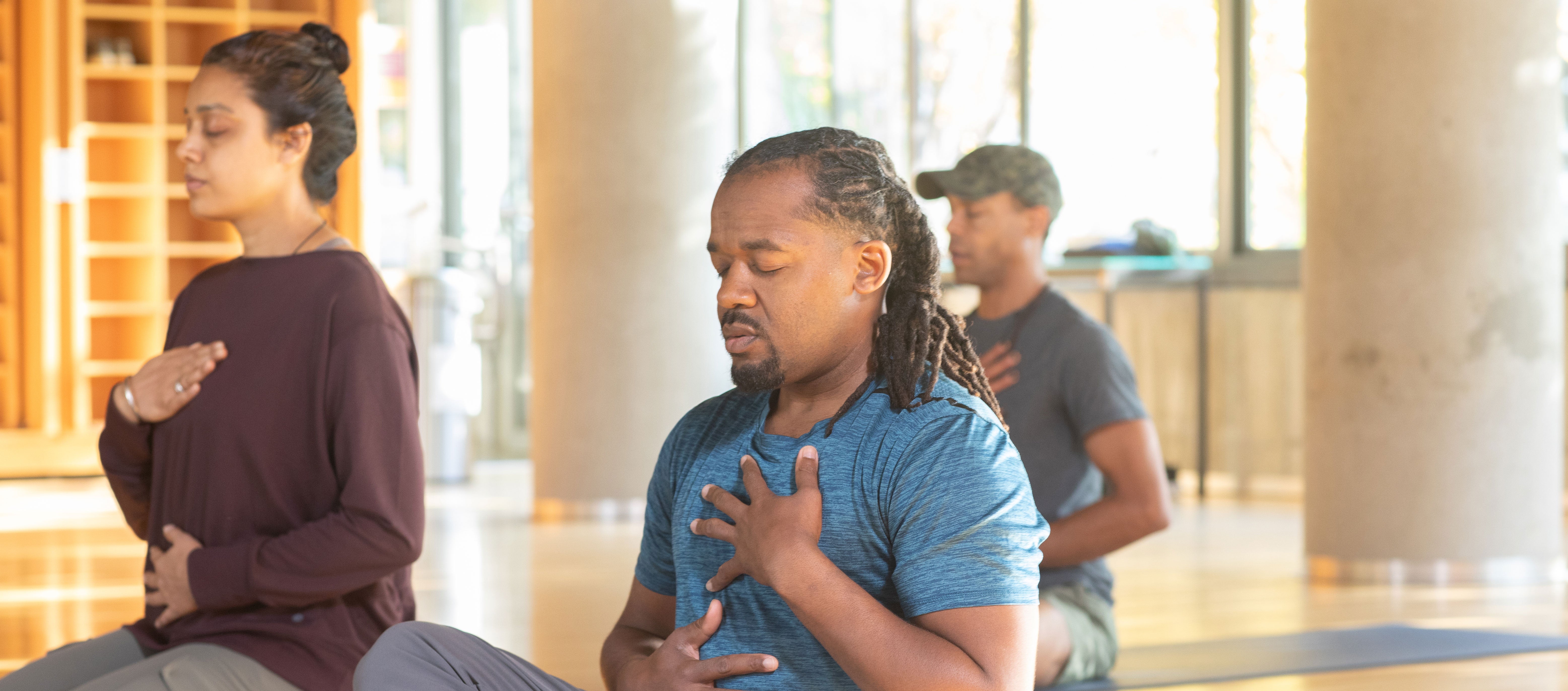 three people doing breathwork