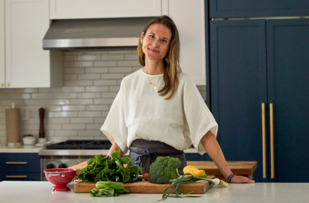 Photo of Nicki Sizemore in a kitchen preparing vegetables.