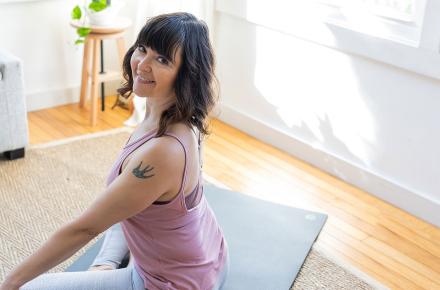 woman smiling on yoga mat