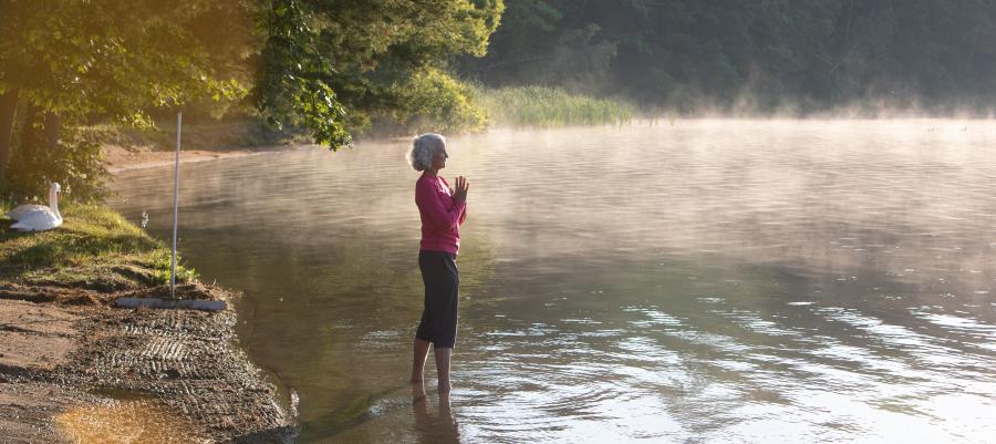 A woman with white hair standing in Lake Mahkeenac